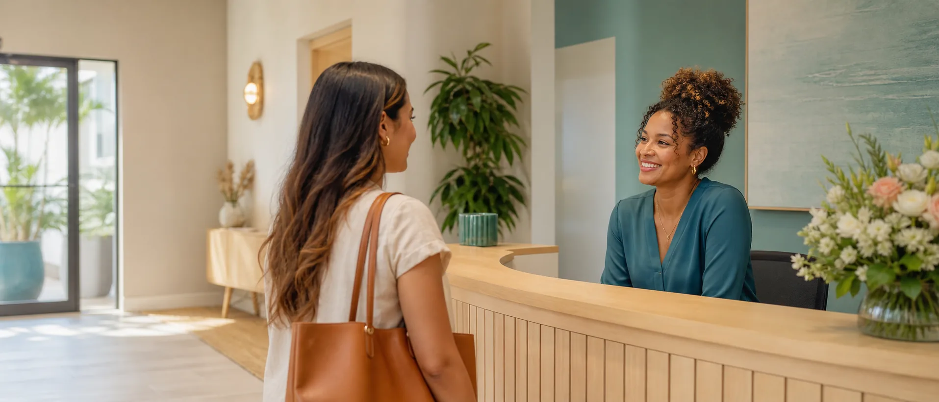 A receptionist welcoming an arriving visitor at the front desk